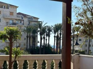 Jaffa Rooftop Studio with Sea Views في تل أبيب: اطلالة على مبنى من شرفة مع نخيل