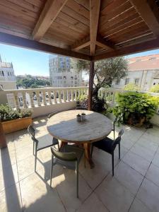 Jaffa Rooftop Studio with Sea Views في تل أبيب: طاولة وكراسي خشبية على الفناء