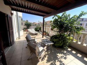 Jaffa Rooftop Studio with Sea Views في تل أبيب: فناء مع كراسي وطاولة على شرفة +صورة واحدة