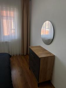 1 dormitorio con tocador y espejo en la pared en Peja Apartment, en Peje