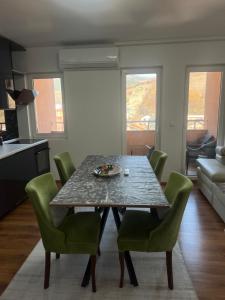Un comedor con una mesa y sillas verdes. en Peja Apartment, en Peje