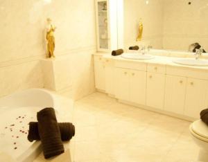 a bathroom with two sinks and a toilet and a tub at Casa Senda Bardenas in Cabanillas
