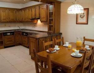 a kitchen with a wooden table with chairs and orange juice at Casa Senda Bardenas in Cabanillas