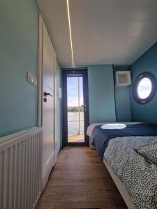 una stanza con una camera da letto con un letto e una finestra di wySPA Kaszuby-domki na wodzie a Ostrzyce