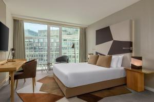 a hotel room with a large bed and a desk and a desk at Room Mate Aitana, Amsterdam in Amsterdam