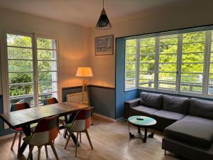 a living room with a couch and a table at Les Fougères - Bois de Cise in Ault