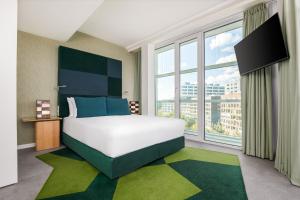 a bedroom with a large bed and a large window at Room Mate Aitana, Amsterdam in Amsterdam
