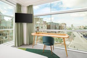 a desk in a room with a large window at Room Mate Aitana, Amsterdam in Amsterdam