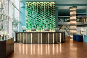 a lobby with a bar with a green wall at Room Mate Aitana, Amsterdam in Amsterdam