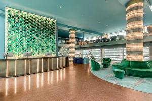 a lobby of a building with green chairs and a counter at Room Mate Aitana, Amsterdam in Amsterdam +93 photos