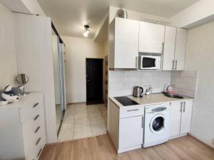 a kitchen with a washing machine and a microwave at New apartments in the city center, Smart TV in Kharkiv