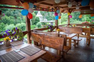 a dining room with wooden tables and colorful balloons at Bilya Richky Hotel in Kamianets-Podilskyi