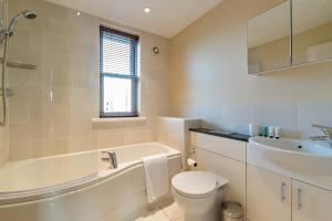 a bathroom with a tub and a toilet and a sink at Camstay New Street in Cambridge