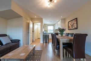 a dining room and living room with a table and chairs at Camstay New Street in Cambridge