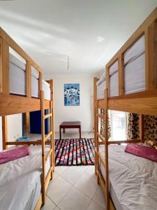 a room with three bunk beds and a table at Locals Taghazout surfcamp in Taghazout