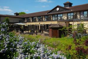 a building with a field of flowers in front of it at Hampshire Court Hotel & Spa in Basingstoke