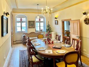a dining room with a large wooden table and chairs at Oswald Hempel, mit 5 Zimmermaisonette und 3 Zimmer Gartenwohnung in Zittau
