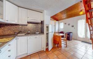 ヴォー・シュル・メールにある1 Bedroom Stunning Home In Vaux-Sur-Merの白いキャビネットとテーブル付きのキッチンが備わります。