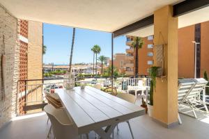 a white table and chairs on a balcony with a view at Luxe 6 pers strand app met zeezicht en zwembad Arenal Beach in Platja de l'Arenal