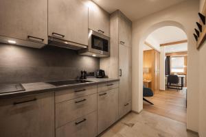 a kitchen with a sink and a microwave at Jochum Hotel Garni in Fiss