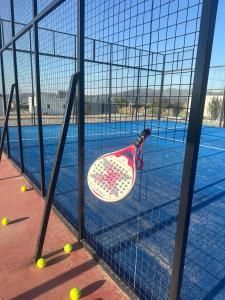 a basket of tennis balls is hanging from a fence at AIRES DEL LAGO, Los Molinos 2 in Potrero de Garay