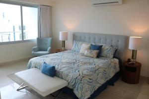 a bedroom with a large bed and a chair at Spectacular Condo With Oceanview in Playa Bonita Village
