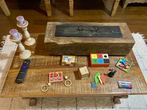 a coffee table with a remote control and items on it at Cantinho Almeida in Tiradentes