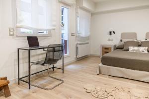 ein Schlafzimmer mit einem Bett und einem Schreibtisch mit Stuhl in der Unterkunft Espacioso apartamento a 9 min playa in Gijón