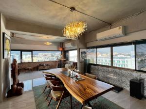 a dining room with a wooden table and some windows at Luxury Apartment in Nimman, 5 mins to Maya in Chiang Mai +16 photos
