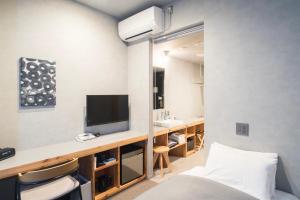 盛岡市にあるホテルマザリウムのベッド1台、テレビ、デスクが備わる客室です。