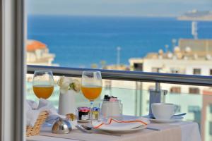 uma mesa com dois copos de vinho numa varanda em Royal Tulip City Center em Tânger