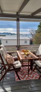a wooden table and chairs on a deck with a table at Rasin Mobile Homes in Pakoštane
