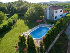 an aerial view of a house and a swimming pool at Rustical Stone house with pool in Ružići