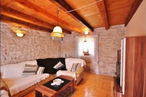 a living room with a couch and a table at Rustical Stone house with pool in Ružići