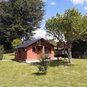 een klein huis in het midden van een veld bij Cabaña El Búho, Lago Puelo in Lago Puelo