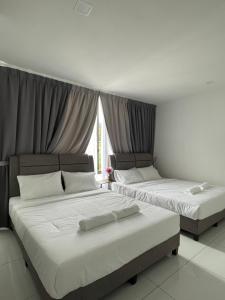due letti in una stanza con una finestra di TDOZE Hotel a Brinchang
