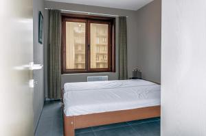 a bedroom with a bed and a window at Mathieu 1 - A2 G in Oostduinkerke