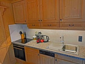 a kitchen with wooden cabinets and a sink at Alkira in Sankt Anton am Arlberg