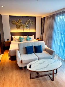 ラワイビーチにあるNew stylish studio in La Vita 5のベッドルーム1室(ベッド1台、ソファ、コーヒーテーブル付)