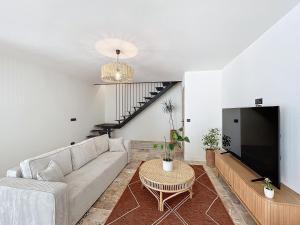 a living room with a couch and a tv at Villa de l'Ange en Provence in Eyragues