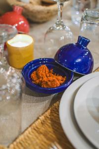 a blue bowl of food on a table with plates at Royal Sahara Dome Camp in Merzouga