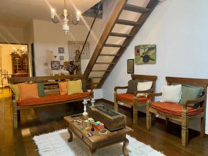 a living room with two couches and a staircase at Cantinho Almeida in Tiradentes