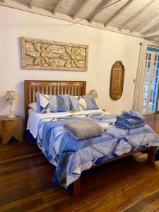 a bed with a blue comforter in a room at Cantinho Almeida in Tiradentes