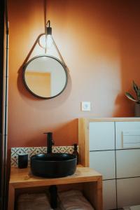 a bathroom with a black sink and a mirror at Aux Trois Chênes Lodges Spas in Mercuès