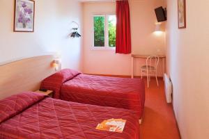 a hotel room with two beds and a window at Premiere Classe Dreux in Dreux