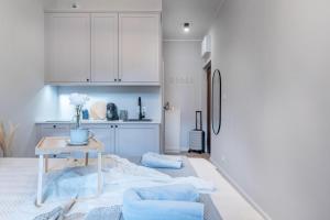 eine weiße Küche mit einem Tisch und einem Kühlschrank in der Unterkunft Piekary Residence in the Center - 18 in Posen + 30 Fotos