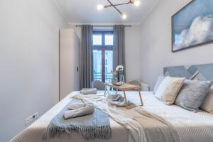 Schlafzimmer mit einem großen Bett und einem Tisch in der Unterkunft Piekary Residence in the Center - 18 in Posen