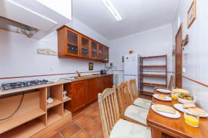 a kitchen with a wooden table and a dining room at Casa do Farol Guesthouse in Lagos
