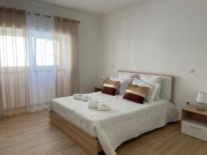 a bedroom with a large bed with two candles on it at Singer's Lounge in Porto de Mós