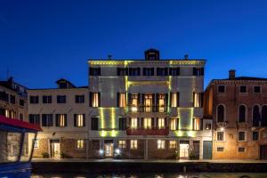 un gran edificio con luces encendidas por la noche en Ca' Bonfadini Historic Experience, en Venecia